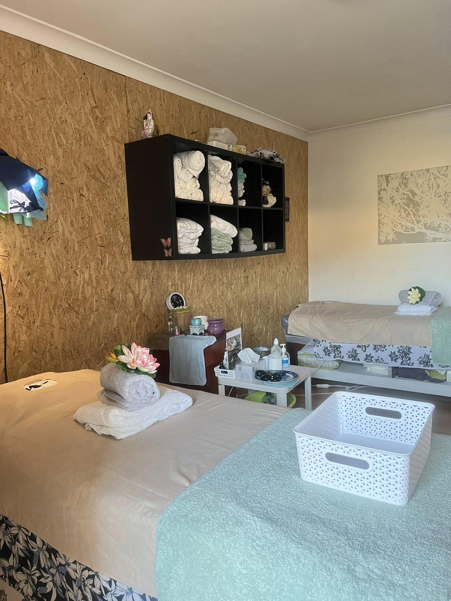 Treatment room with massage tables and natural wood walls